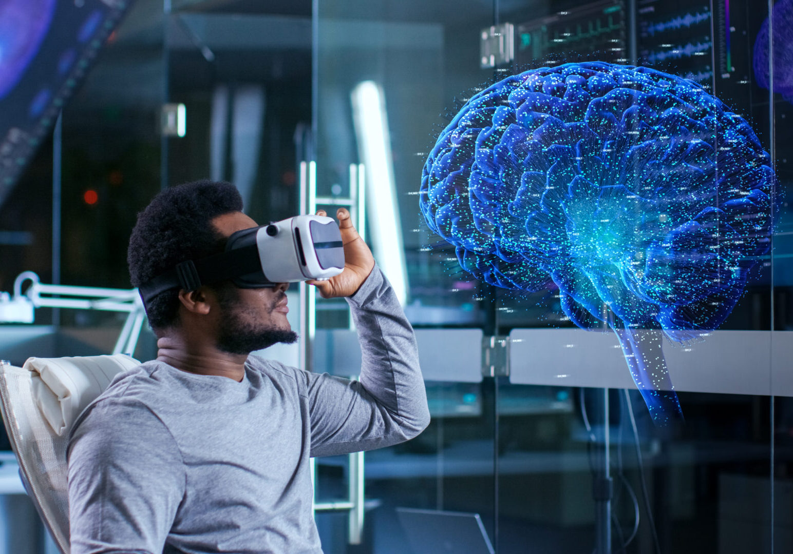 In Laboratory Scientist Wearing Virtual Reality Headset Sitting in a Chair Interacts With Monitors Showing Brain Activity, and Neurological Data. Brain hologram. Modern Brain Study/ Neurological Research Center.